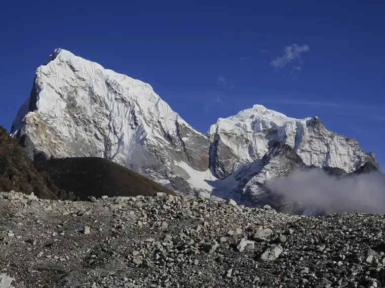 Snow peaks above a boulder field on the moraine