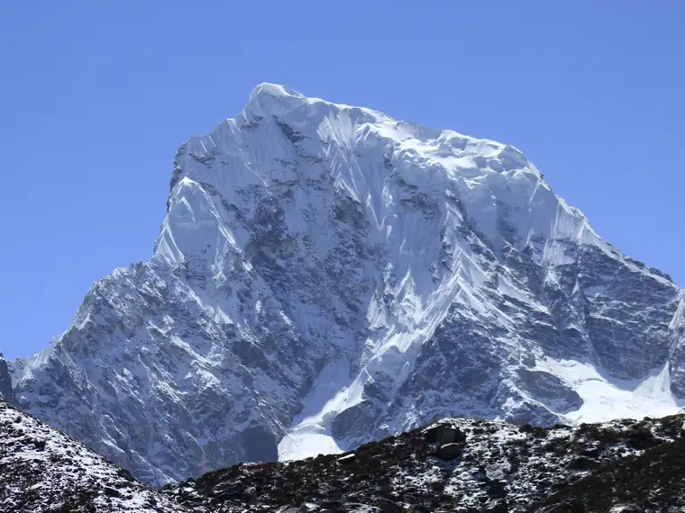 A snow-covered peak against a clear blue sky