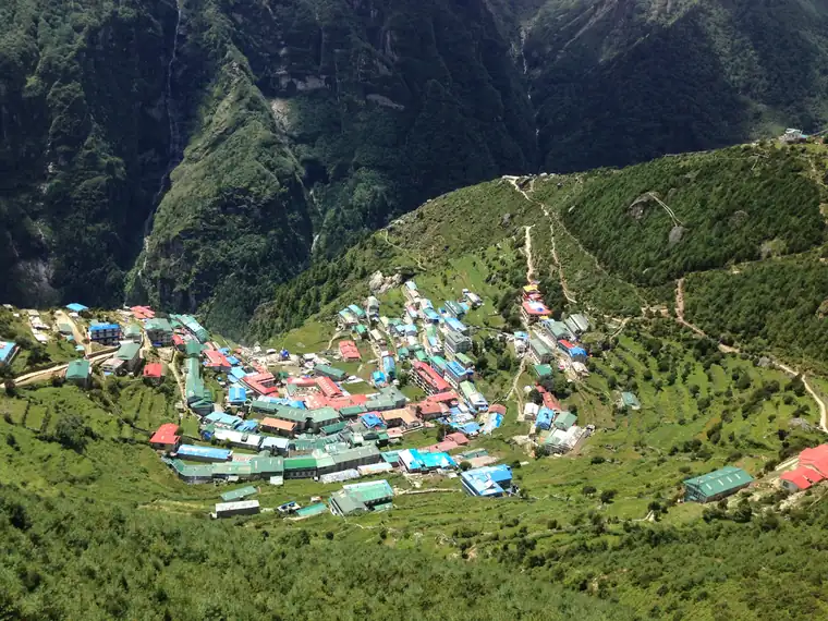 Namche Bazaar seen from above, its houses curved around the hillside