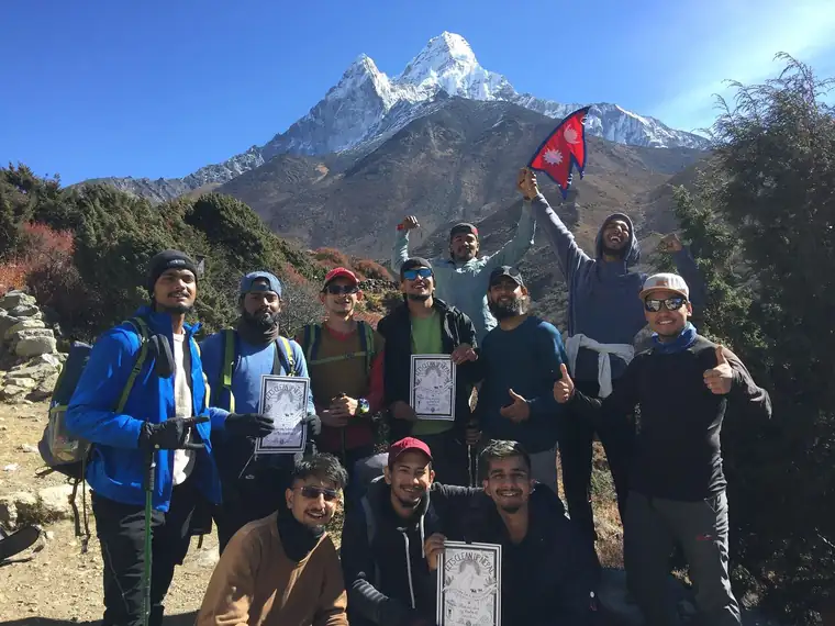 A Himalayan Green Trips group holding their certificates, Ama Dablam behind