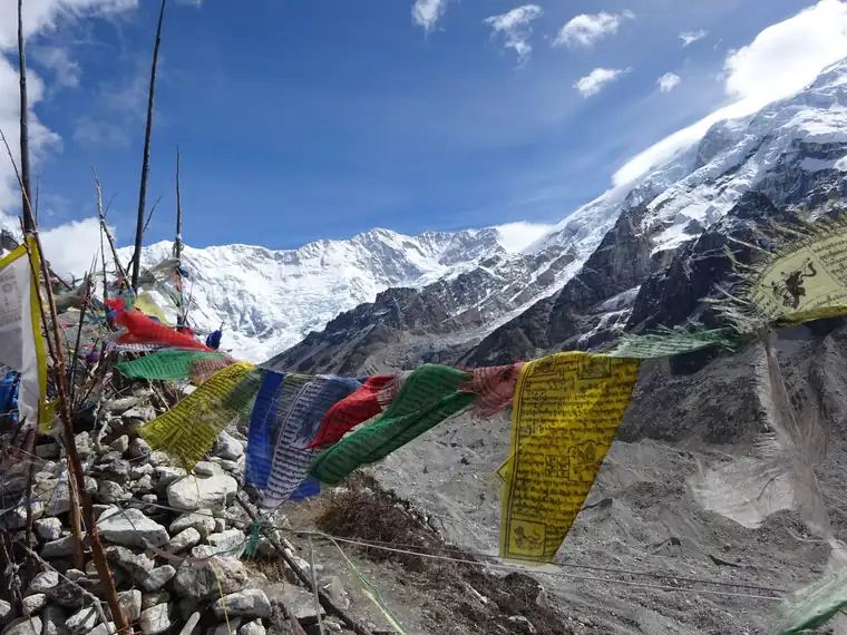 Prayer flags on a cairn, with Kanchenjunga's snowfields beyond